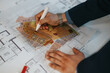 © qunica.com - Person focusing on analyzing an architectural and layout plan with overlay of urban planning visual