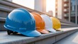 © Nia - Colorful construction hard hats lined up on steps outside a building