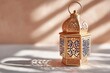 © Natalia - Ornamental copper lantern casting beautiful shadows on a white tablecloth