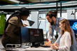 © DC Studio - Young engineer in office requests help from IT experts detecting and blocking hacker intrusion. Female programmer assisted by staff members coordinating incident response for network attack