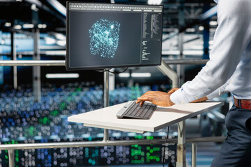 black software engineer reviews machine learning systems on computer, standing on industrial platfor