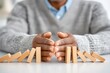 © Luiri Art - Close up of hands stopping falling dominoes, symbolizing conflict resolution, crisis prevention, decision making, and responsible leadership in times of tension or uncertainty