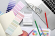© Pixel-Shot - Calendar with paint color palettes, eyeglasses and laptop on light background