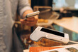 © Maria Vitkovska - Customer paying contactless with mobile phone at pos terminal
