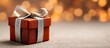 © AspctStyle - Red glittery gift box wrapped with a shiny silver ribbon and bow, placed on a neutral surface with soft golden bokeh lights in the background, evoking a festive and elegant celebration