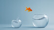 © Ilham Fathony - A golden goldfish leaps from its confining fishbowl into the bigger aquarium, a daring jump for bigger opportunity