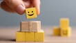 © hestywinarni - Close-up of a hand placing a smiling face emoji block on top of a stack of cardboard boxes, with additional boxes around, symbolizing happiness, packaging, and positivity in a minimalistic setting