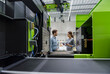 © BusinessClass by W61 - Colleagues in high tech company controlling manufacturing machines, using digital tablet
