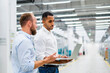 © BusinessClass by W61 - Two businessmen with laptop having a meeting in a factory