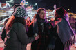 © qunica.com - A cozy group of friends talking and sharing moments in a vibrant carnival atmosphere.