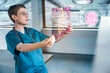 © BusinessClass by W61 - Doctor analyzing holographic heart scan in futuristic hospital
