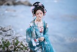 Serene woman in traditional attire by the water Chinese word means flower.