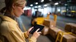 © ryker - Female warehouse supervisor is using tablet to check inventory in busy warehouse filled with boxes and equipment, showcasing efficiency and focus
