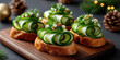 Three elegant cucumber canapés on wooden board. Topped with cheese and herbs. Surrounded by Christmas decorations like pine cones and ornaments.