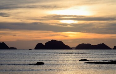 Wall Mural - serene sunset over ocean with silhouetted islands