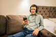 © Mediteraneo - Little boy on road trip in apartment using phone with headphones