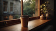 © kyungtae - A cozy and warm product shot of a blank paper coffee cup sitting on a window sill in a home. The image's soft, diffused light and domestic setting are perfect for a lifestyle or home-based brand.
