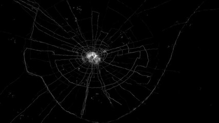 A close-up view of a cracked piece of glass on a black background. The cracks are thin and white