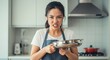 © tea - Frustrated Woman Holding Frying Pan in Kitchen - A young woman in an apron displays a frustrated expression while holding a frying pan.