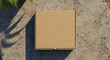 © elkhan - Overhead view of a closed, blank cardboard pizza box on a textured stone surface.