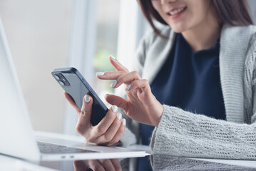 happy asian business woman using smartphone, online working on laptop computer, surfing the internet