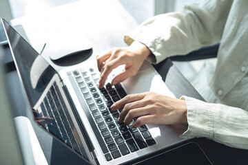 Wall Mural - close up of business woman hands typing on laptop computer and digital tablet, searching and surfing