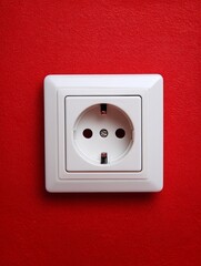 Wall Mural - of a recessed European socket on a red wall, with flat background and crisp white edges for visual contrast recessed European socket red wall background contrast white edge primary color clean 