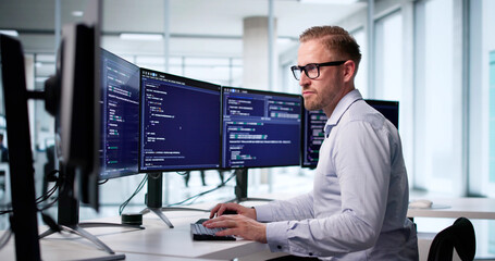 Male Software Engineer Coding At Office Computer Screen