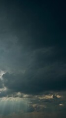Wall Mural - Sun Rays Shining Through Dark Storm Cloudy Rainy Sky With Fluffy Rain Clouds. Sky Natural Background. Weather Forecast Concept