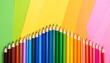 © Edge - A row of sharpened colored pencils arranged in a gradient yellow background