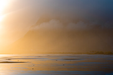 Wall Mural - Mud flat view with mountain covered by fog.