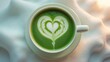 © Sona - Green latte art heart in a cup, with a white background. Coffee and beverage arts, concept. Drink presentation and creativity. The concept of artistic beverage decoration.