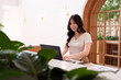 © snowing12 - Asian adult woman remote working on laptop computer in modern cafe freelance business productivity digital nomad lifestyle