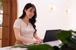 © snowing12 - Asian adult woman freelancer remote working online on laptop computer smiling at modern cafe desk