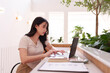 © snowing12 - Asian adult woman independent professional remote work laptop use modern cafe for digital business productivity development