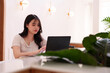 © snowing12 - Asian woman freelancer works online laptop computer modern cafe coffee shop digital nomad productive focused remote work study bright workspace