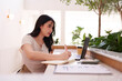 © snowing12 - Asian woman working freelance business using laptop writing notes cafe modern workspace digital nomad productive environment independent career professional study