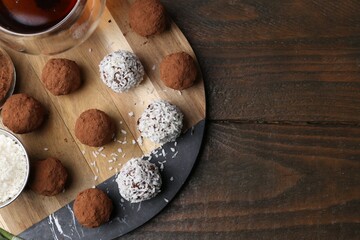 Wall Mural - delicious homemade candies with cocoa powder, coconut flakes and tea on wooden table, flat lay. spac