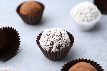 Wall Mural - delicious homemade candies with cocoa powder and coconut flakes on light grey table, closeup