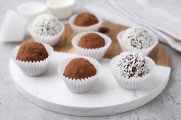 Wall Mural - delicious homemade candies with cocoa powder and coconut flakes on light grey table, closeup