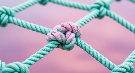 A closeup of a knotted rope net with a soft pastel background