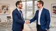 © Kasivat - Two businessmen in navy suits shake hands with smiles, celebrating a successful deal in a modern office.