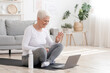 © Prostock-studio - Smiling Senior Woman Training At Home Online Via Laptop, Waving Hand At Camera, Greeting Fitness Instructor, Exercising In Living Room, Copy Space