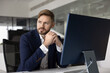 © fizkes - Pensive concerned young businessman looking away, sitting at office workplace table, thinking on problem solving, financial troubles, crisis management ideas, making serious decision