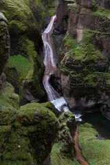 Canvas Print - a small waterfall flows between the cliffs.