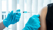 © Thitiphat - Doctor making a vaccination into patient with needle getting immune vaccine at arm for flu shot, coronavirus protective of epidemic