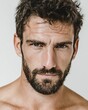 © Fathor - Portrait of a handsome man with a beard looking at the camera, isolated on a white background. Close-up view, studio shot, wearing a white t-shirt.