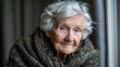 © Darya - Elderly woman with silver hair in cozy knitted shawl, warm portrait of elderly lady indoors
