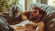 © Yevhen - Man perspires heavily on couch while seeking relief from summer heatwave with a fan