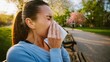 © uniyok - Woman sneezing in park due to pollen allergy in spring weather